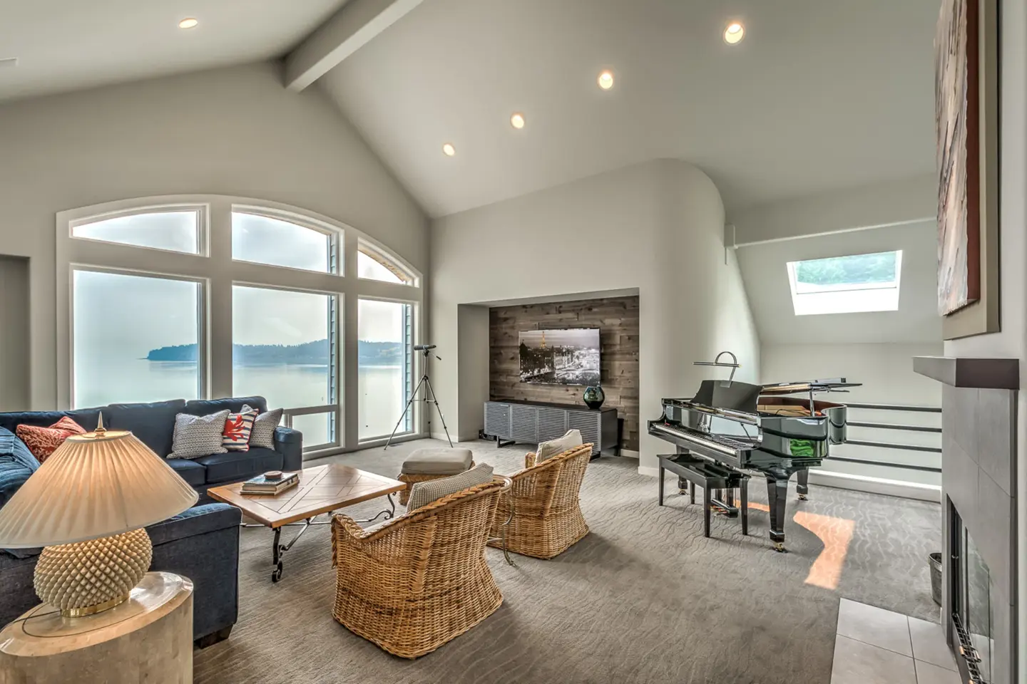 Vaulted waterfront living room remodel with arched windows overlooking Puget Sound, Camano Island