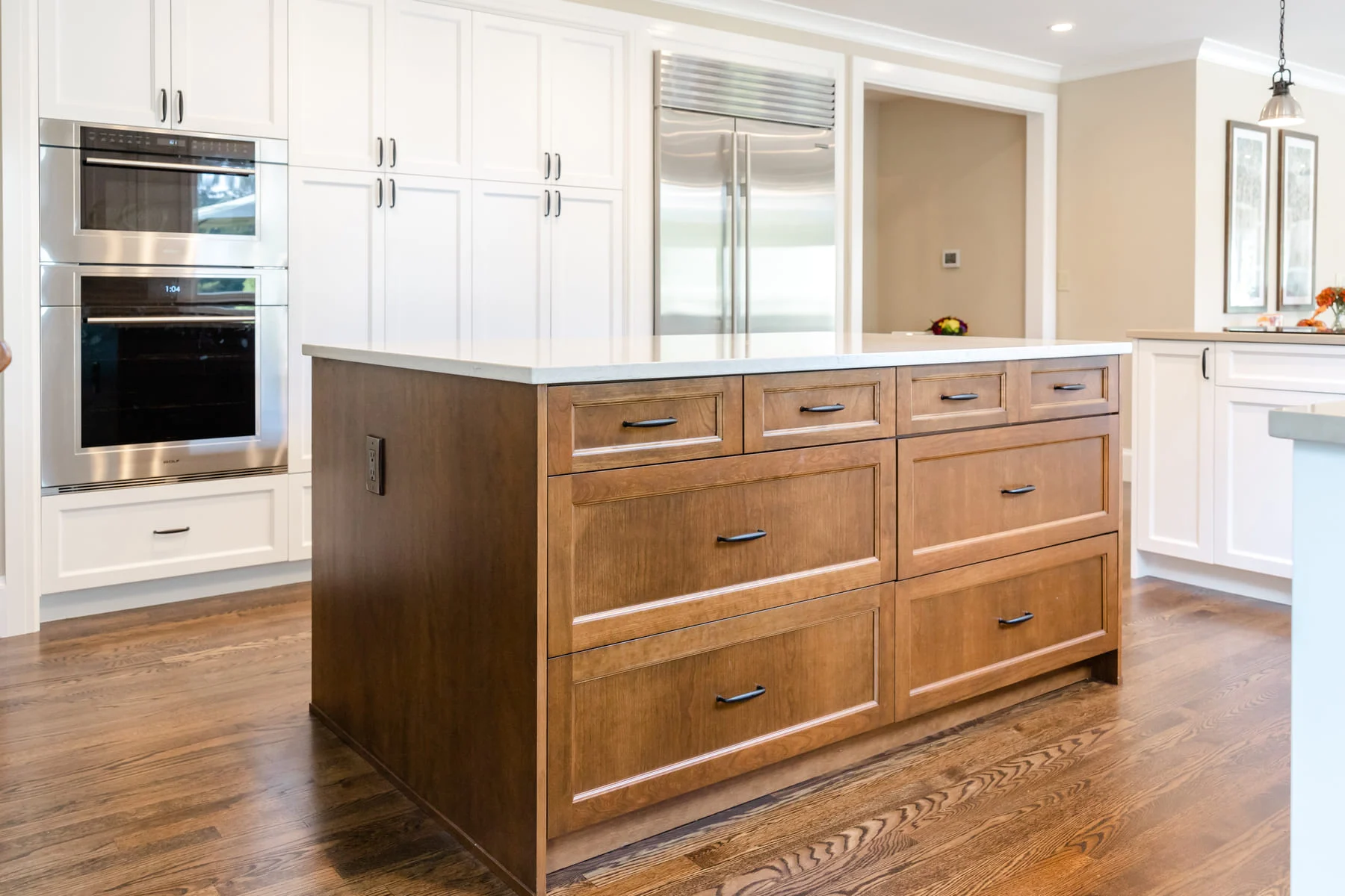 Kitchen remodel with stained-wood island and white perimeter cabinetry